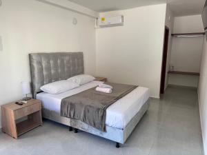 a bedroom with a bed with a pink towel on it at Hotel Santorini in San Gil