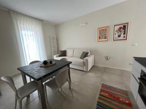 sala de estar con mesa y sofá en MyVilla - Ivrea Corso M. d'Azeglio, 59 en Ivrea