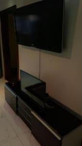 einen Flachbild-TV, der an einer Wand hängt in der Unterkunft PINEVALLEY APT .SUITE 3A 