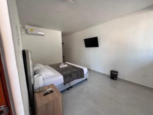 a small bedroom with a bed and a tv at Hotel Santorini in San Gil
