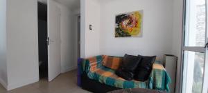 ein Wohnzimmer mit einem Sofa und einem Gemälde an der Wand in der Unterkunft La Casita de Hotei in Mar del Plata