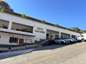 a hotel with two cars parked in a parking lot at Hotel Santorini in San Gil