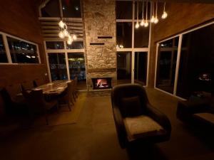 a dining room with a fireplace and a table and chairs at Villa Noar, Cozy 4BR Mountain w, Fireplace, Lake View, Brezovicë in Brezovica