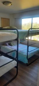 een kamer met 3 stapelbedden en een raam bij Amanecer de Costa del Sol in Lago Rapel