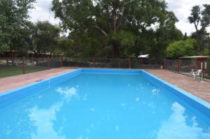 una gran piscina azul en un patio en El Refugio in 