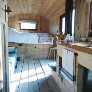 a bedroom in a tiny house with a bed at River Meadow Retreat in Uffculme