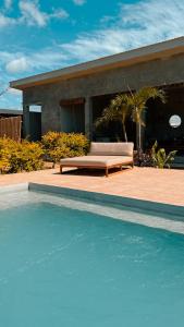 uma piscina em frente a uma casa com um sofá em Tukasa - Surfhouse Popoyo em Popoyo