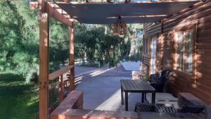 a patio with a table and an umbrella at Cabaña La Escondida in Trelew
