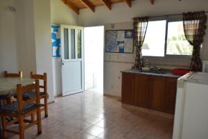 a kitchen with a table and a sink and a table at Hostal Madryn in Puerto Madryn