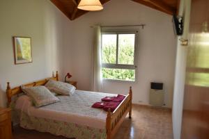 1 dormitorio con cama y ventana en Hostal Madryn en Puerto Madryn