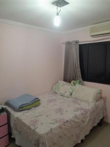 a small bedroom with a bed and a window at Residencial in Salvador