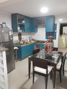 a kitchen with blue cabinets and a table and chairs at Residencial in Salvador