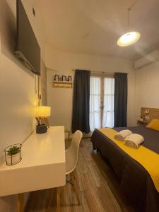 a bedroom with a bed and a table and a window at Mora Hostel in Mendoza +104 photos