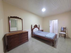 a bedroom with a bed and a mirror and a dresser at Suíte 2 com sala in Lages