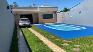 uma casa com piscina em frente a uma casa em Pousada Ferreira 415 em São Gabriel