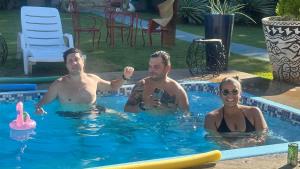 un grupo de tres personas en una piscina en Pousada Vilagio Chapada, en Chapada dos Guimarães