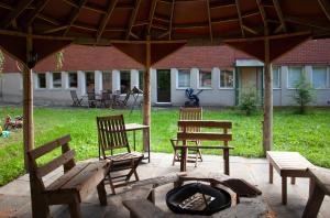 un patio con sillas de madera y una hoguera en Jaala Hotel en Kouvola