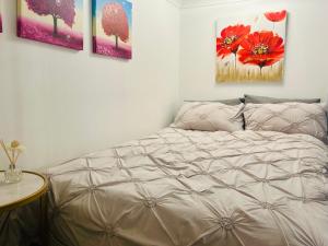 a bedroom with a bed with four paintings on the wall at Glasgow Center/West End Apartment in Glasgow