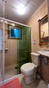 uma casa de banho com um WC, um chuveiro e um lavatório. em Casa com vista a praia da Barra do Sahy em Barra do Sahy
