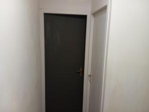 una porta nera con maniglia d'oro in una stanza di Chambre Calme meublé proche aéroport rocade a Pessac
