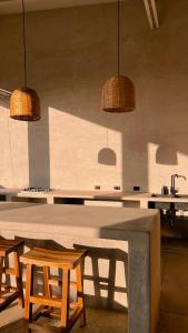 eine Küche mit einem Tisch, Stühlen und Hängelampen in der Unterkunft Tukasa - Surfhouse Popoyo in Popoyo