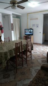 a living room with a table with chairs and a television at CasaTribuno in Salta