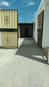 an empty garage with a gate and a building at CasaTribuno in Salta