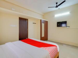 a bedroom with a bed with a red blanket at OYO Flagship Srinivasa Residency in Chennai