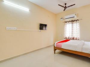 1 dormitorio con 1 cama y ventilador de techo en OYO Flagship Srinivasa Residency en Chennai