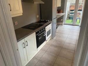 a kitchen with white cabinets and a stove at bnb in Belfast