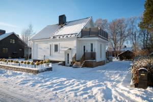 una casa blanca en la nieve en el patio en Guestly Homes - 4BR Cozy Corporate Villa, en Piteå