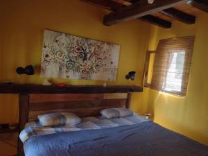 1 dormitorio con 1 cama y una pintura en la pared en Posada Los Nogales en Junín