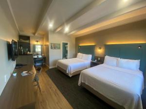 a hotel room with two beds and a television at Castle Inn in Cambria