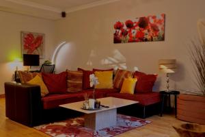 a living room with a red couch and a table at Fernway Residence entire property in Cork