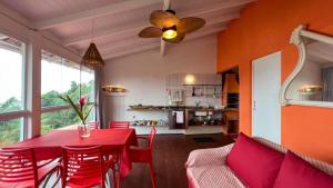 ein Esszimmer mit einem roten Tisch und roten Stühlen in der Unterkunft Casa com vista a praia da Barra do Sahy in Barra do Sahy