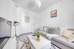 a living room with a couch and a table at Appartement Cosy I Proche de la Porte de Versailles Paris in Malakoff