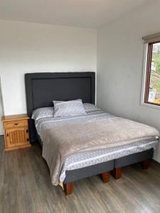 1 dormitorio con 1 cama grande y mesita de noche en AMPLIA CASA CON VISTA HERMOSA A TODA LA BAHIA, en Viña del Mar