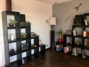 una sala de estar con estanterías negras con libros en AMPLIA CASA CON VISTA HERMOSA A TODA LA BAHIA en Viña del Mar