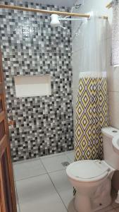 a bathroom with a toilet and a glass shower at Chalé Recanto da Cachoeira II in Capela Ivapurunduva