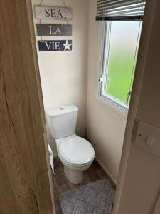 a small bathroom with a toilet and a window at Primrose valley - Primrose Field 46 holiday home in Filey