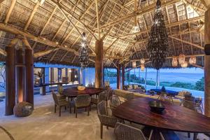 een restaurant met tafels en stoelen en een groot plafond bij Casa Koko NEW 6-Suite Ocean-View Luxury Villa in Punta Mita