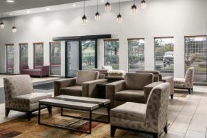 une salle d'attente avec des chaises, des tables et des fenêtres dans l'établissement Garner Hotel Auburn - Seattle, an IHG Hotel, à Auburn