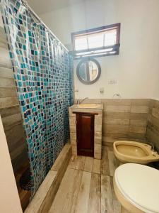 W łazience znajduje się toaleta, umywalka i lustro. w obiekcie Mini house con sol y luz w BuenosAires
