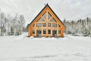 a log cabin in the snow with trees at Le Chalet Enchanté in Saint-Donat-de-Montcalm