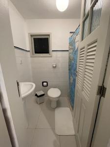 a small bathroom with a toilet and a sink at Casa Teresa in Rio de Janeiro