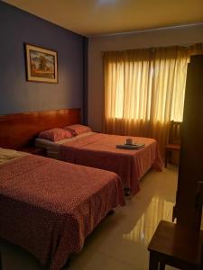 Habitación de hotel con 2 camas y ventana en Hotel ESPLENDOR, en Chiclayo