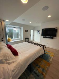 a bedroom with a large bed with a flat screen tv at Private, cozy, suite by Mile High Stadium and Downtown Denver! in Denver