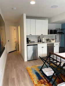 a kitchen with white cabinets and a table with a rug at Private, cozy, suite by Mile High Stadium and Downtown Denver! in Denver