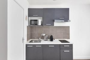 a kitchen with a sink and a microwave at Studio Cosy Paris/CDG/Expo/Stade in Aulnay-sous-Bois