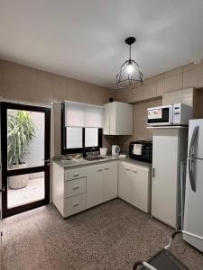 eine Küche mit weißen Schränken und einem Kühlschrank in der Unterkunft Departamento de Josefina in Santiago del Estero